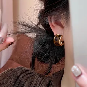 Retro golden hoop earrings with leopard faux horsehair inlay shown on a model