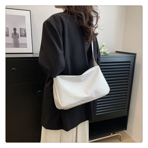 Minimalist white soft leather tote bag styled with a professional black blazer outfit