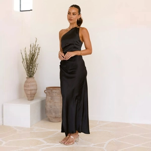 Detalle de un elegante vestido largo de satén negro con un hombro descubierto y abertura