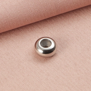 Macro view of silver round stainless steel positioning bead with a large hole for DIY jewelry