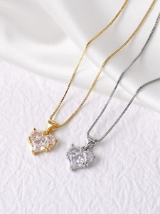Detail view of heart-shaped zircon pendant necklaces in gold and silver finish