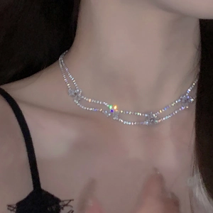 Nahaufnahme der zweilagigen silbernen Halskette mit Strass-Sternen am Model
