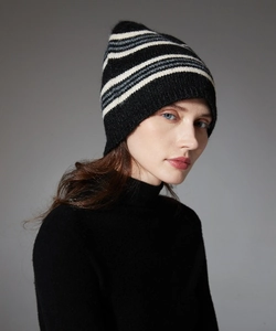 Close-up of a striped wool knit beanie worn by a model in a professional studio setting