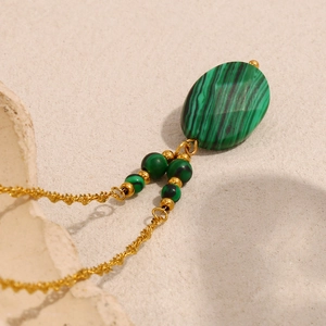 Detail of 18K gold plated oval green malachite star pendant with twisted chain