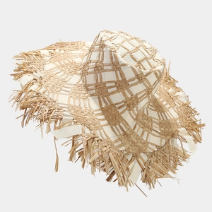Detail of two-tone raffia sun hat featuring a wide fringed brim and woven check pattern