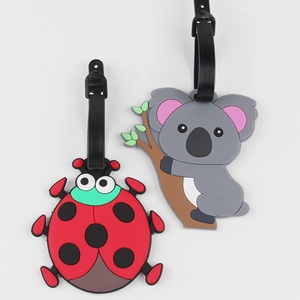 Silicone ladybug and koala luggage tags with black straps on a white background