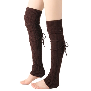 Close-up of dark brown knit leg warmers featuring retro cable pattern and lace-up ribbons