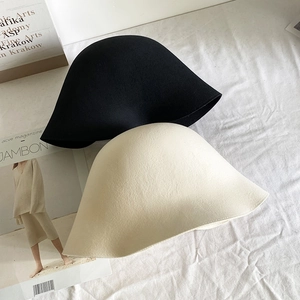 Vue à plat de chapeaux cloches en laine minimalistes en feutre noir et crème
