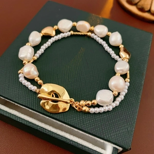 Detail of double-layer baroque pearl bracelet with a large golden toggle clasp