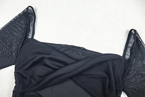 Détail de la robe noire à col en V avec manches bouffantes en tulle et texture plissée