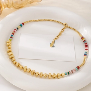 Chic 18k gold plated beaded necklace with colorful natural stones in a white ceramic dish