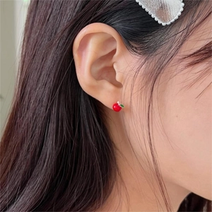 Minimalist 925 silver red cherry stud earrings with green leaf detail on a female model