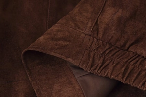 Detailansicht der dunkelbraunen Wildlederjacke mit elastischem Bündchen und feinen Nähten