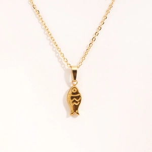 Close-up of a gold-plated titanium steel tropical fish pendant necklace on white background