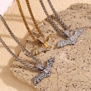Vue macro des pendentifs chauve-souris hip hop avec diamants sur colliers en or et argent