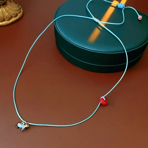 Detail of adjustable blue cord necklace with cute puppy pendant and colorful beads