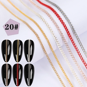 Macro shot of assorted colorful metal nail art chains shown on black manicured tips