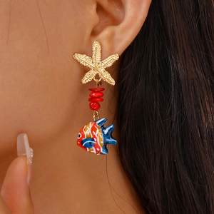 Detail of starfish stud and colorful tropical fish pendant on a beach vacation earring