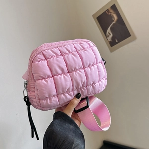 Detailed shot of pink quilted nylon crossbody bag with wide shoulder strap and zipper