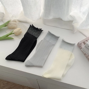 Detailed knit texture of ballet style sheer socks in black, grey, and cream colors