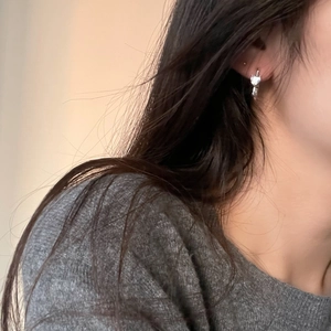 Detailed view of minimalist 925 silver heart dangle earrings with zircon on a model
