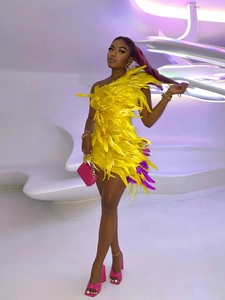 Détail de la robe jaune asymétrique avec plumes violettes et coupe moulante ajustée