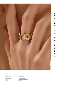Close-up of a wide irregular golden stainless steel ring on a model's finger