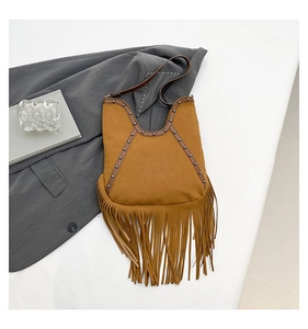 Detail of brown suede tassel bag with metal rivets and sun embossed pattern