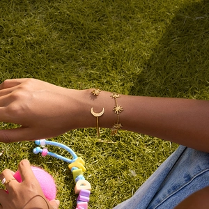 Ensemble bracelet et jonc en or 18 carats avec soleil et lune porté en plein air