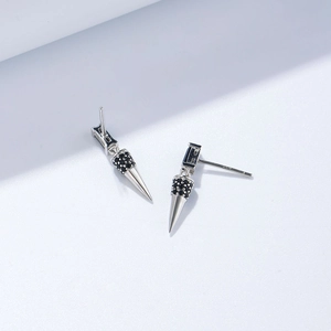Macro detail of S925 sterling silver cone earring with black zircon in punk style