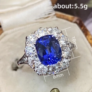 Lujoso anillo de zafiro azul real con circonitas plateadas en un joyero de estilo vintage