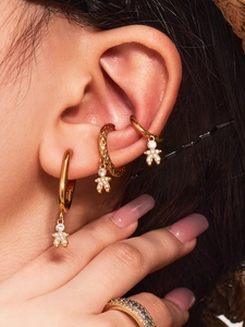 Detail of PVD gold plated teddy bear earrings with crystals on a female model