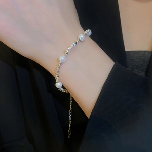 Gros plan d'un collier double rang en perles et argent porté par un mannequin élégant