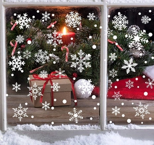 Détail de stickers flocons de neige statiques blancs sur une vitre décorée pour Noël