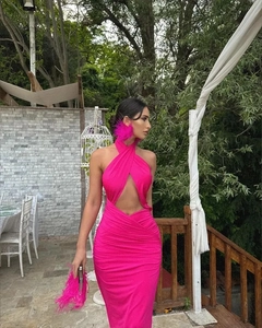 Detail view of pink halter neck pleated dress with feather earring and evening clutch bag