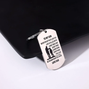Macro shot of silver stainless steel dog tag keychain with father-son silhouette engraving