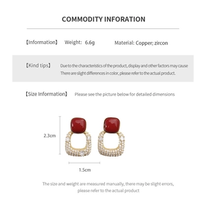 Détail des boucles d'oreilles carrées vintage dorées avec zircon rouge et info taille