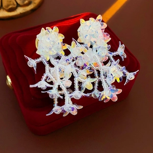 Macro shot of colorful floral beaded tassel earrings on a premium red velvet jewelry box