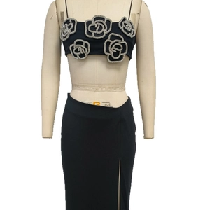 Fashionable black two-piece set featuring rhinestone rose camisole and side slit maxi skirt