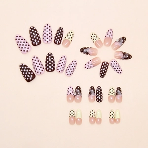 Detailed flat lay of French style press-on nails with 3D floral and polka dot patterns