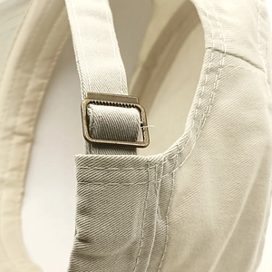 Close-up of adjustable cotton military cap with vintage bronze metal buckle and stitching