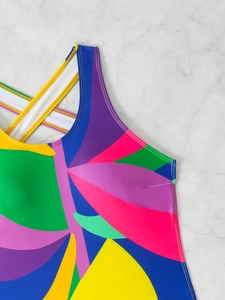 Close-up of vibrant botanical print swimsuit with crisscross straps and contrast stitching