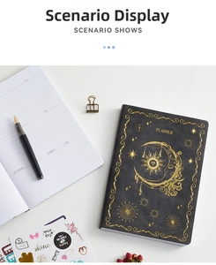 Detail of celestial planner with gold foil moon and sun patterns on black cover