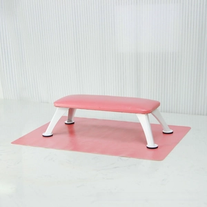Macro detail of the pink leather pedicure footrest with white metal non-slip support frame