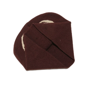 Detailed close-up of dark burgundy ribbed knit hat featuring white curved graphic embroidery