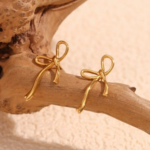 Elegant 18K gold plated stainless steel bow stud earrings on natural wood stand