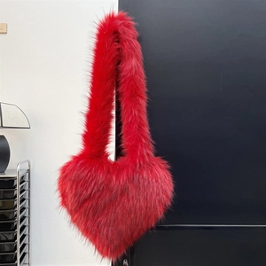 Detail of red heart-shaped fluffy faux fur crossbody bag with long plush shoulder strap