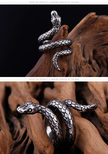 Close-up of vintage snake ring with detailed silver scales on textured wood surface