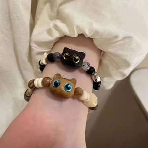 Close-up of cat-shaped beaded bracelets with natural wood beads on a model's wrist