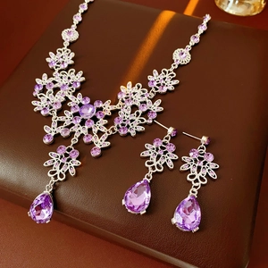 Detailed view of vintage jewelry set with purple drop zirconia and silver flower motifs